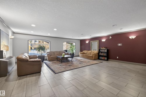Living area with a textured ceiling, recessed lighting, and crown molding - 427 13005 140 Avenue, Edmonton, AB - Indoor