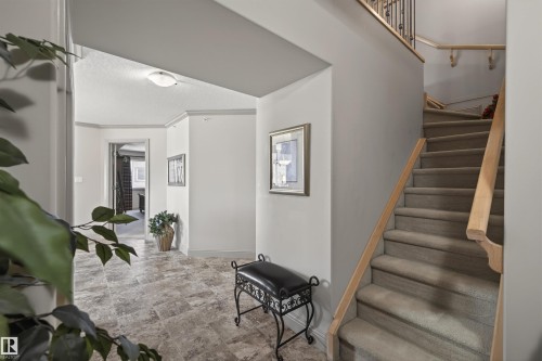 Staircase featuring baseboards and stone finish flooring - 427 13005 140 Avenue, Edmonton, AB - Indoor Photo Showing Other Room