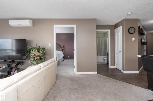 Living area with a textured ceiling and carpet floors - 325 1520 Hammond Gate, Edmonton, AB - Indoor