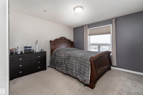 Bedroom with a textured ceiling and light carpet - 325 1520 Hammond Gate, Edmonton, AB - Indoor Photo Showing Bedroom