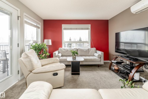 Living area with carpet floors and plenty of natural light - 325 1520 Hammond Gate, Edmonton, AB - Indoor Photo Showing Living Room