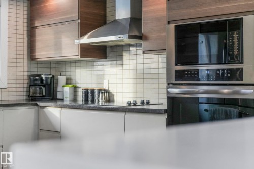 Kitchen featuring black appliances, dark countertops, and decorative backsplash - 14924 81 Street, Edmonton, AB 