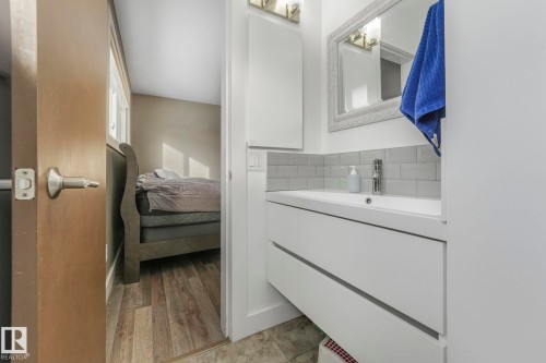 Bathroom with vanity, ensuite bathroom, light wood-type flooring, and backsplash - 14924 81 Street, Edmonton, AB 