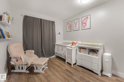Bedroom featuring wood finished floors and a crib - 14924 81 Street, Edmonton, AB 