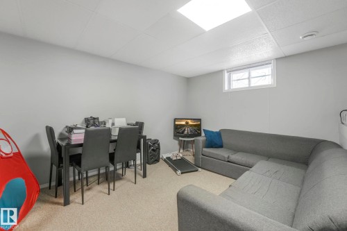 Living room with a drop ceiling and light colored carpet - 14924 81 Street, Edmonton, AB 
