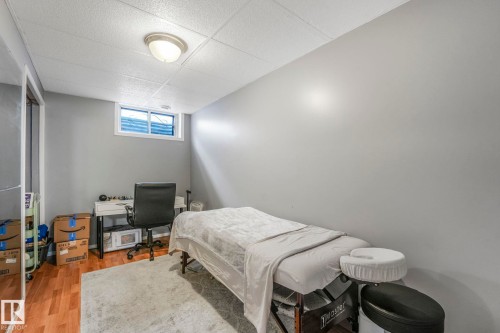 Bedroom featuring wood finished floors, a drop ceiling, and an office area - 14924 81 Street, Edmonton, AB 