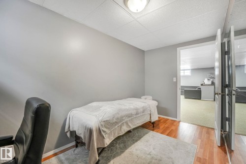 Bedroom featuring light wood-style flooring and a paneled ceiling - 14924 81 Street, Edmonton, AB 