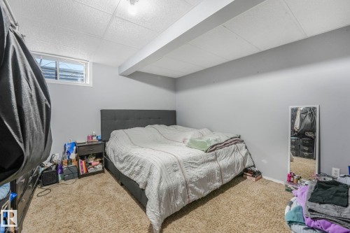 Carpeted bedroom featuring a drop ceiling and baseboards - 14924 81 Street, Edmonton, AB 