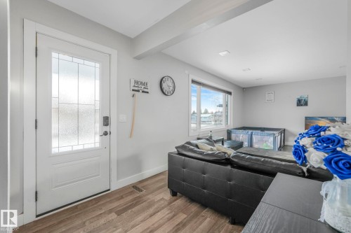 Living room featuring wood finished floors and beamed ceiling - 14924 81 Street, Edmonton, AB 