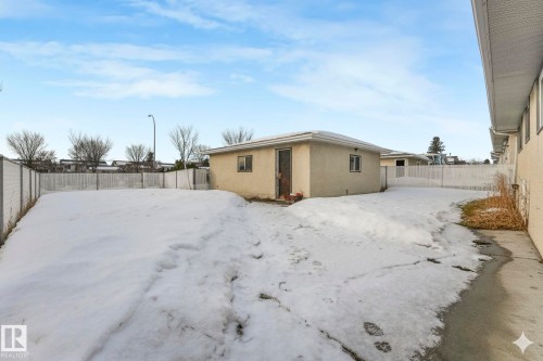 Snow covered back of property with a fenced backyard and stucco siding - 14924 81 Street, Edmonton, AB 