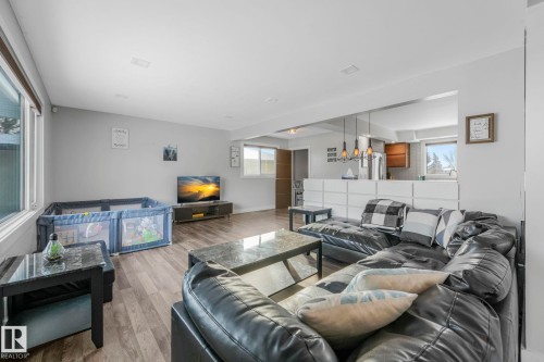 Living room featuring light wood-style floors, healthy amount of natural light, and suspended lighting - 14924 81 Street, Edmonton, AB 