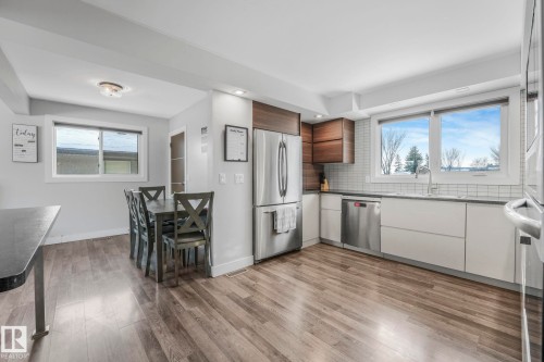 Kitchen with stainless steel appliances, decorative backsplash, modern cabinets, light wood finished floors, and recessed lighting - 14924 81 Street, Edmonton, AB 