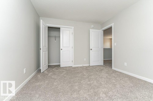 Unfurnished bedroom featuring a closet, a textured ceiling, and light carpet - 3949 Wren Loop, Edmonton, AB - Indoor Photo Showing Other Room