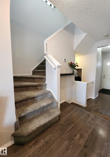 Staircase with wood finished floors and a textured ceiling - 5424 204 Street, Edmonton, AB - Indoor Photo Showing Other Room