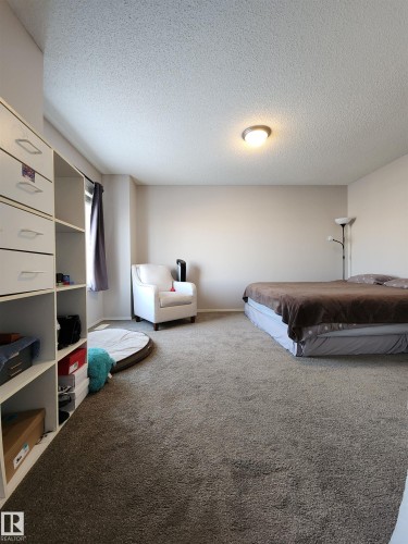 Carpeted bedroom featuring a textured ceiling and billiards - 5424 204 Street, Edmonton, AB - Indoor