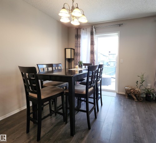 Dining space with a textured ceiling, dark wood finished floors, and suspended lighting - 5424 204 Street, Edmonton, AB - Indoor Photo Showing Dining Room