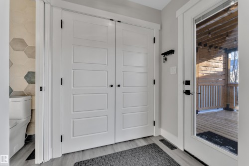 Doorway to outside with wood finished floors and baseboards - 7613 16 Av Sw, Edmonton, AB - Indoor Photo Showing Other Room