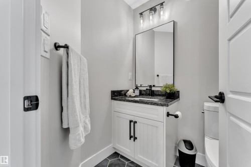 Half bath featuring vanity and dark tile patterned flooring - 7613 16 Av Sw, Edmonton, AB - Indoor Photo Showing Bathroom