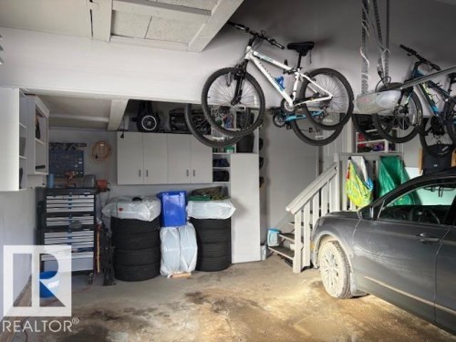 Double garage with cabinets and above ground storage - 867 Armitage Wynd Sw, Edmonton, AB - Indoor Photo Showing Garage