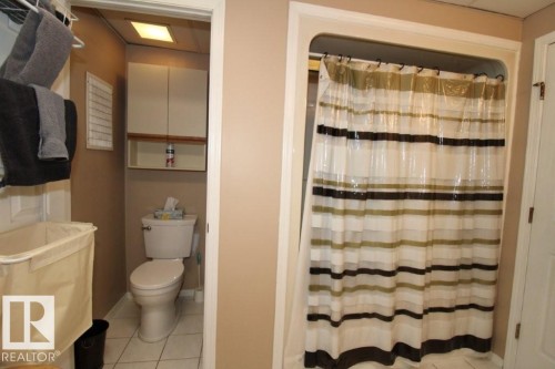 Full bathroom with a shower with shower curtain and light tile patterned floors - 2812 35 Street Nw, Edmonton, AB - Indoor Photo Showing Bathroom