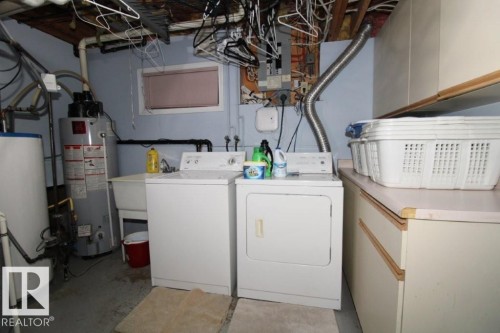 Laundry area with water heater, concrete floors, washer and clothes dryer, and electric panel - 2812 35 Street Nw, Edmonton, AB - Indoor Photo Showing Laundry Room