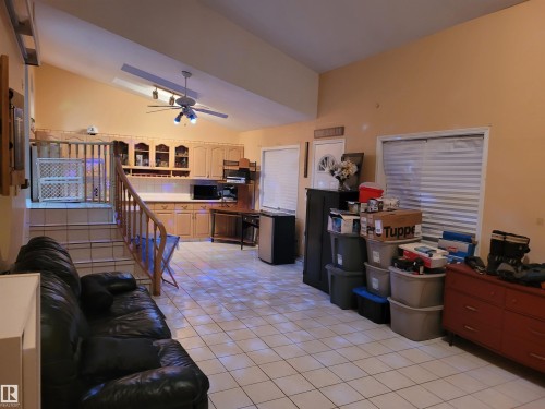 Living area with vaulted ceiling, light tile patterned floors, and a ceiling fan - 2812 35 Street Nw, Edmonton, AB - Indoor