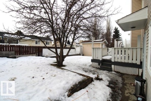 Snowy yard featuring a wooden deck, a fenced backyard, and an outdoor structure - 2812 35 Street Nw, Edmonton, AB - Outdoor With Deck Patio Veranda