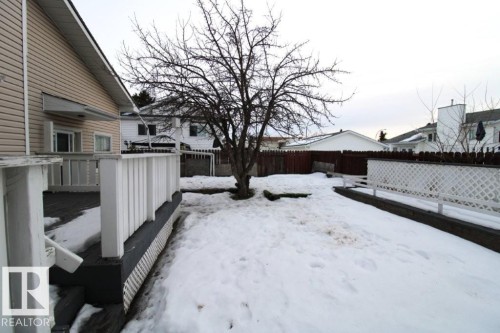 Yard layered in snow with a wooden deck and a fenced backyard - 2812 35 Street Nw, Edmonton, AB - Outdoor