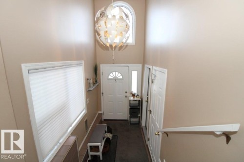 Doorway to outside with a chandelier, carpet flooring, and a high ceiling - 2812 35 Street Nw, Edmonton, AB - Indoor Photo Showing Other Room