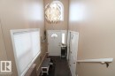 Doorway to outside with a chandelier, carpet flooring, and a high ceiling - 2812 35 Street Nw, Edmonton, AB  - Indoor Photo Showing Other Room 