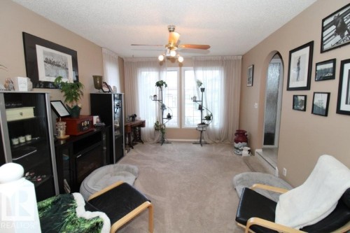Living area featuring arched walkways, a ceiling fan, a textured ceiling, and carpet - 2812 35 Street Nw, Edmonton, AB - Indoor