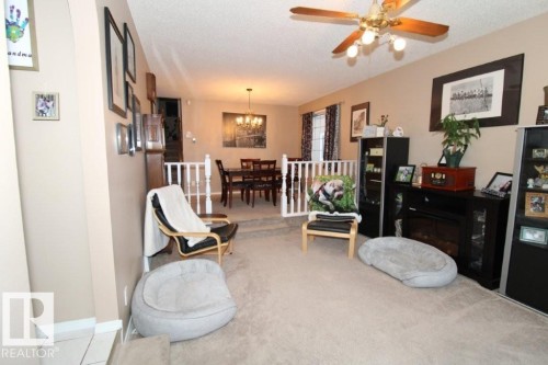 Sitting room with a textured ceiling, a ceiling fan, and a glass covered fireplace - 2812 35 Street Nw, Edmonton, AB - Indoor
