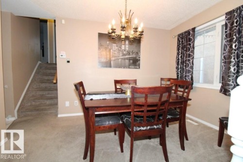 Dining area with suspended lighting, a textured ceiling, and light colored carpet - 2812 35 Street Nw, Edmonton, AB - Indoor Photo Showing Dining Room