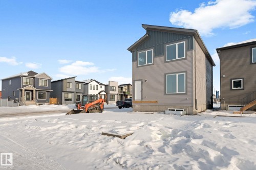 Snow covered property featuring a residential view and board and batten siding - 94 Blackbird Bend, Fort Saskatchewan, AB - Outdoor