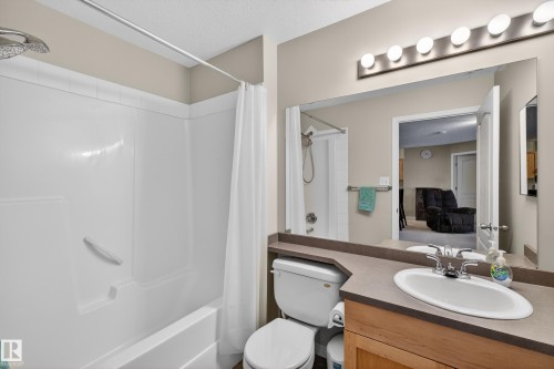 Bathroom with vanity, shower / tub combo, and a textured ceiling - 131 1520 Hammong Gate, Edmonton, AB - Indoor Photo Showing Bathroom