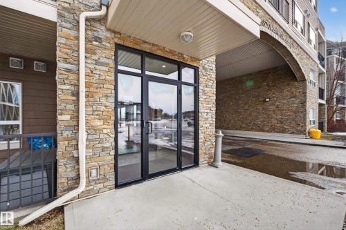 Entrance to property with stone siding and a patio area - 131 1520 Hammong Gate, Edmonton, AB - Outdoor With Exterior