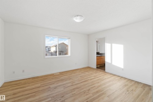 Unfurnished bedroom featuring light wood-style floors and ensuite bath - 4507 164A Avenue, Edmonton, AB - Indoor
