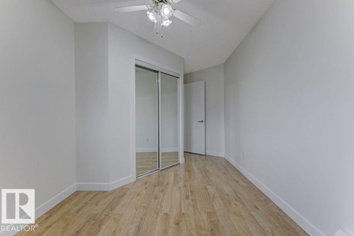 Unfurnished bedroom featuring light wood-type flooring, a closet, ceiling fan, and a textured ceiling - #117 5005 31 Avenue, Edmonton, AB - Indoor Photo Showing Other Room
