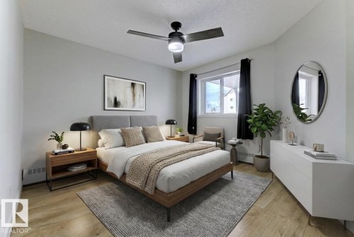 Bedroom with light wood-style flooring, a ceiling fan, a textured ceiling, and a baseboard heating unit - #117 5005 31 Avenue, Edmonton, AB - Indoor Photo Showing Bedroom