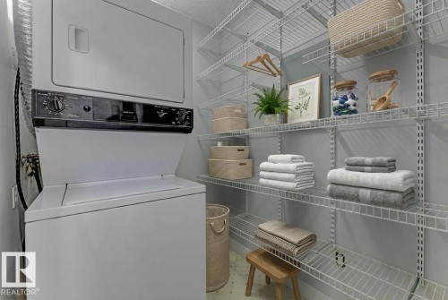 Laundry room with stacked washer and dryer - #117 5005 31 Avenue, Edmonton, AB - Indoor Photo Showing Laundry Room
