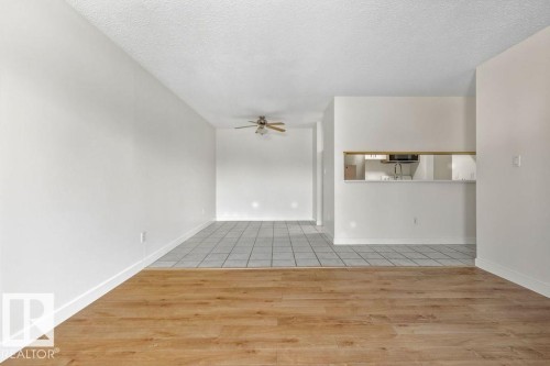 Empty room with light wood-type flooring, a textured ceiling, and ceiling fan - #117 5005 31 Avenue, Edmonton, AB - Indoor Photo Showing Other Room