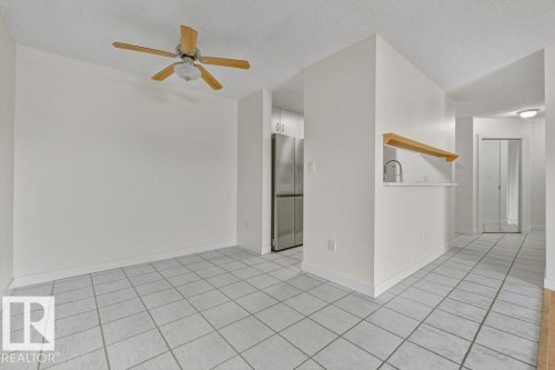 Unfurnished room featuring a textured ceiling, light tile patterned flooring, and ceiling fan - #117 5005 31 Avenue, Edmonton, AB - Indoor Photo Showing Other Room