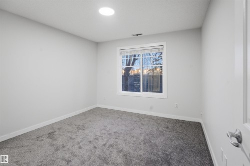 Unfurnished bedroom with ensuite bath, light carpet, and a closet - 115 2098 Blackmud Creek Drive, Edmonton, AB - Indoor Photo Showing Other Room