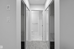 Hallway featuring baseboards and light marble finish flooring - 