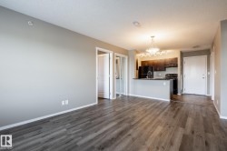 Kitchen featuring dark countertops, black appliances, a textured ceiling, open floor plan, and a peninsula - 