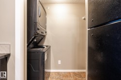 Laundry area featuring stacked washing machine and dryer and baseboards - 