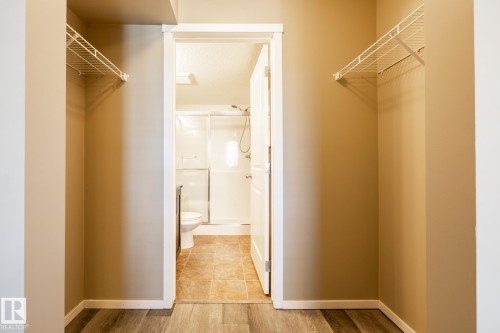Walk in closet with light wood-style floors - 433 3315 James Mowatt Trail, Edmonton, AB - Indoor With Storage