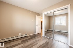 Unfurnished bedroom featuring a baseboard radiator, wood finished floors, a closet, and a textured ceiling - 