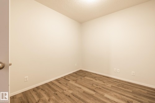 Unfurnished room with a textured ceiling and wood finished floors - 433 3315 James Mowatt Trail, Edmonton, AB - Indoor Photo Showing Other Room