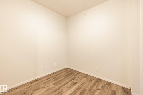 Spare room with a textured ceiling and wood finished floors - 433 3315 James Mowatt Trail, Edmonton, AB - Indoor Photo Showing Other Room